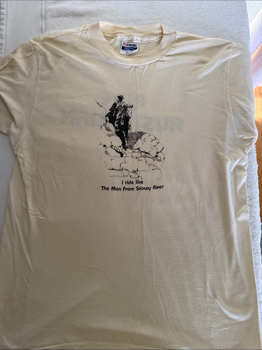 1980s Men’s cream colored t. With “Ride like the man from SnowyRiver “ size L
